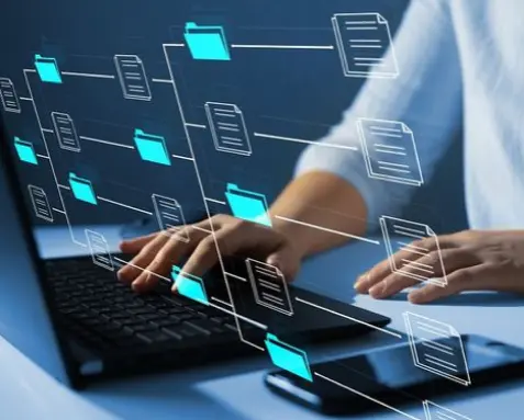 Developer working on a laptop with holographic database icons, representing MuleSoft certified developer's knowledge in managing relational and non-relational databases like SQL, MySQL, and Oracle for processing and storing large volumes of data.