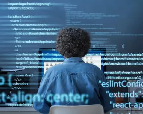 Back view of a developer working on code with holographic text overlays, illustrating MuleSoft developers adhering to best practices and standards to ensure reliable, scalable, and maintainable integration solutions.