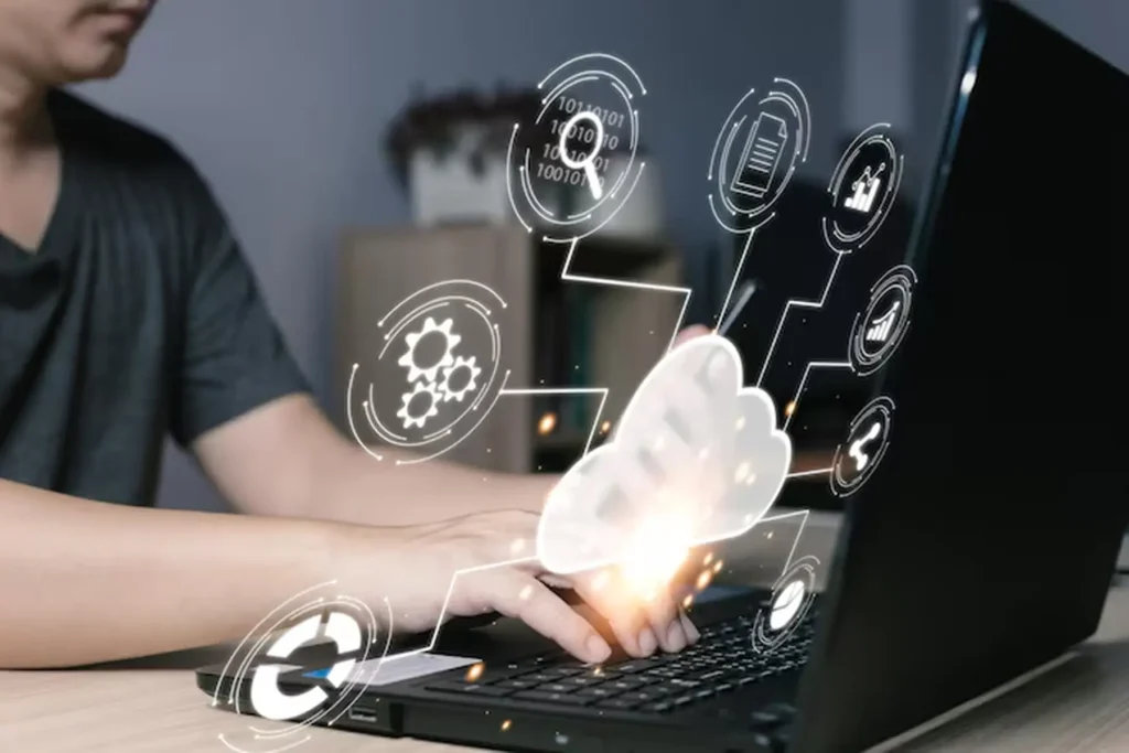 Person typing on a laptop with cloud and integration icons, symbolizing AI deployment services that ensure smooth integration with existing tools, apps, and workflows from day one.