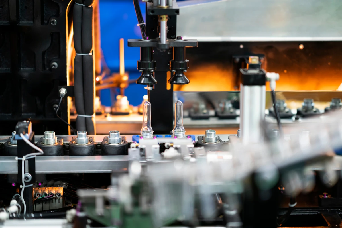 Close-up of an industrial machine in operation, with a focus on automated processes, symbolizing the use of data-driven React applications for streamlining production workflows and inventory management in manufacturing.