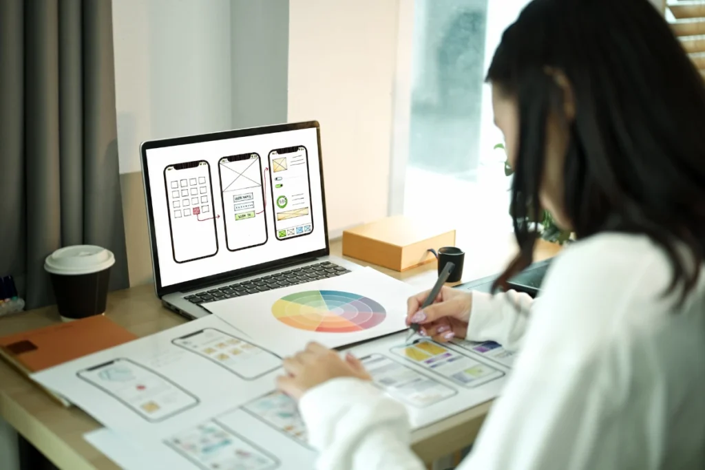 Developer designing responsive UI for custom React web app using wireframes and prototypes, showcasing hire ReactJS developers for scalable web development solutions.