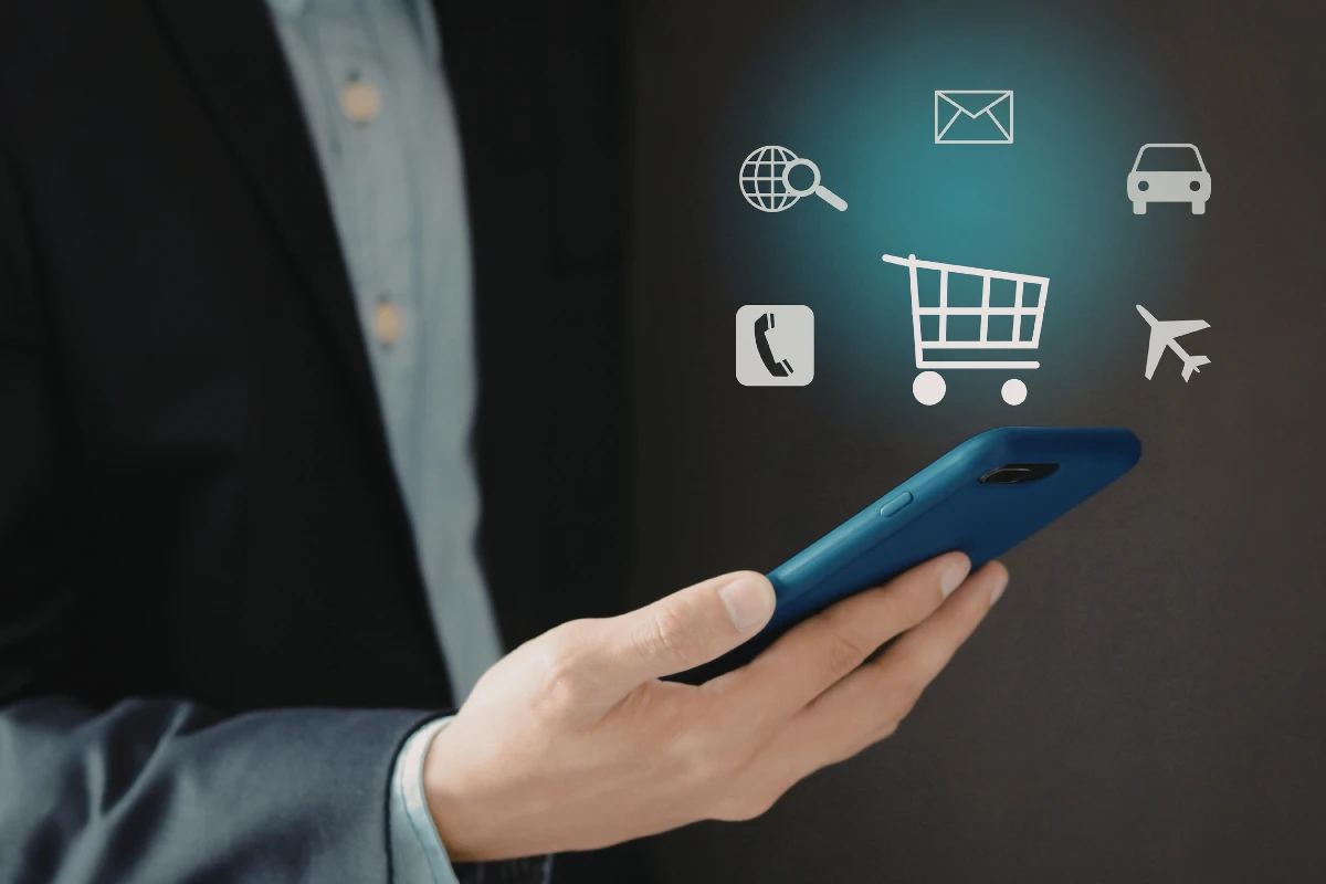 A person using a smartphone with floating icons representing e-commerce features like shopping cart, search, contact, and transportation, illustrating the use of ReactJS for building responsive and engaging online store experiences.