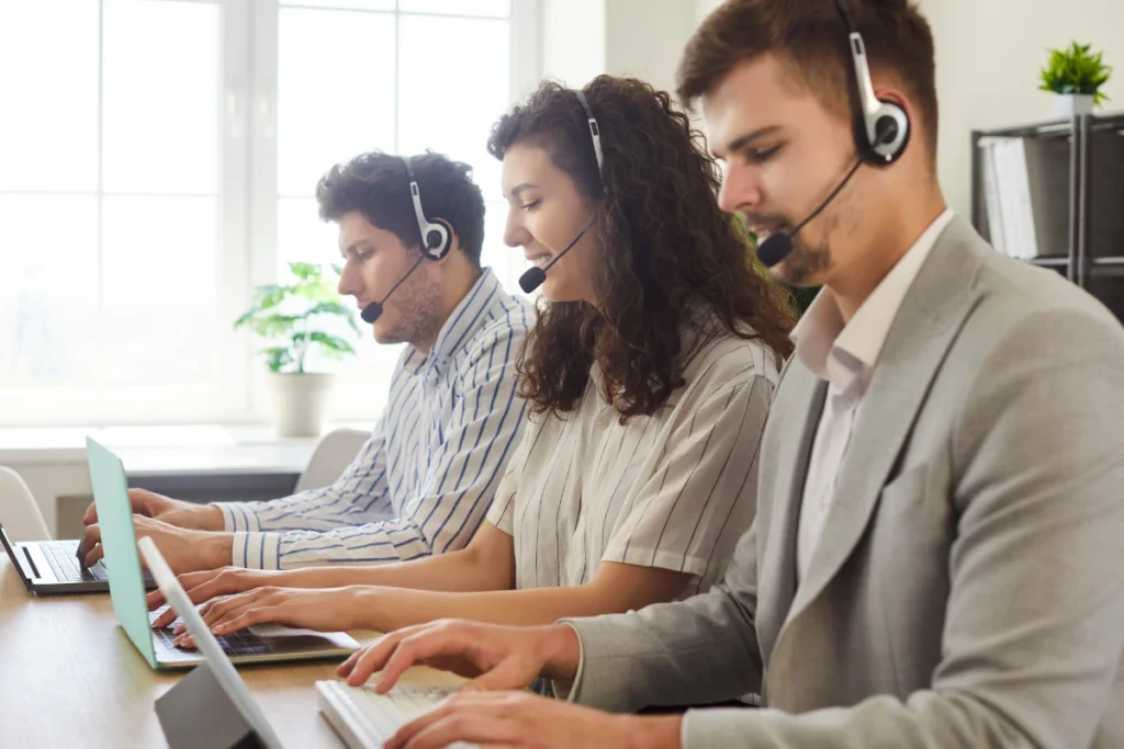 A customer support team working together with headsets, providing ongoing support and updates for React applications to ensure they remain secure, stable, and up-to-date.